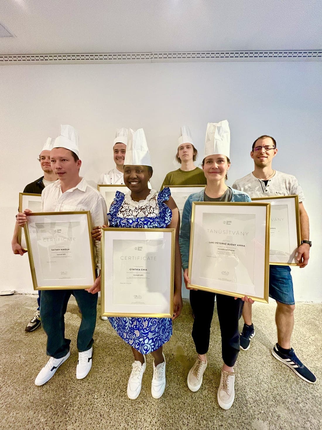 Cynthia holding her Culinary Arts certificate from the Culinary Institute of Europe